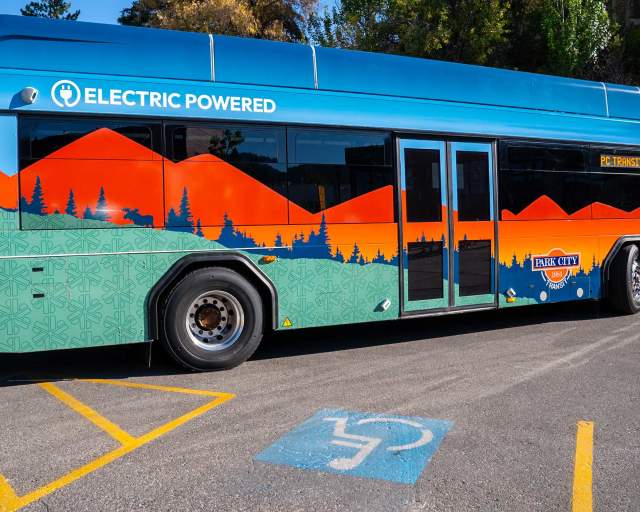 An electric bus stops in front of a handicap parking spot in Park City, UT