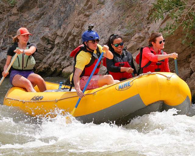 Women Rafting Down River with Wellness Whitepaper Graphic in left-hand corner
