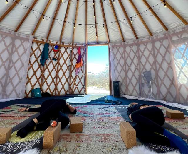 Two students do  yoga in a yurt near Park City, UT