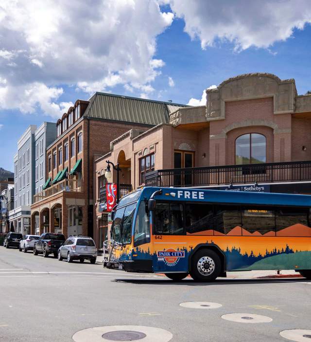 A city bus crosses Main Street on a sunny day in Park City, UT