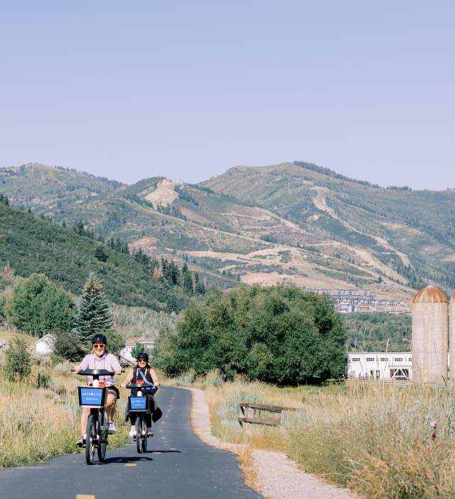 Two people riding summit bike share