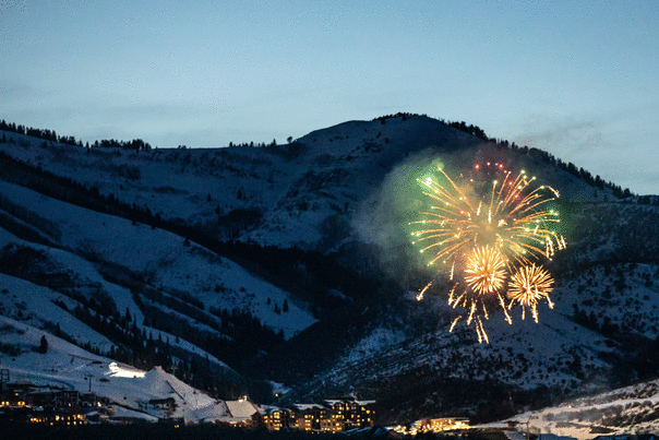 Fireworks explode over an event at dusk during the winter in Park City, UT