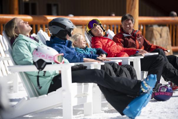 Family sitting on ski beach soaking up the sun