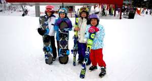 kids with snowboards and skis