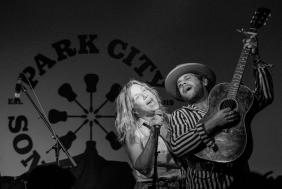 Two performers sing a song together on a stage