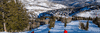 Three skiers descend a freshly groomed run on a sunny winter day at Deer Valley Resort in Park City, UT