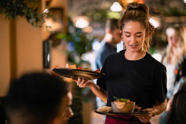 A waitress delivers two plates of food in a cozy restaurant in Park City, UT