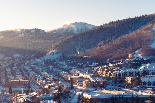 View of Park City Mountain and Historic Old Town in Park City, UT at sunrise on a snowy winter day.