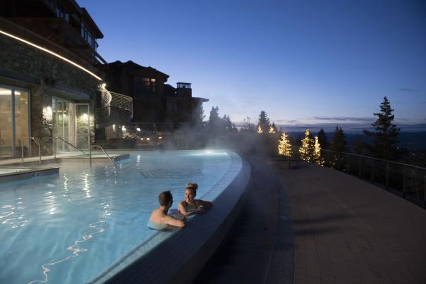 Poolside view of a couple enjoying the sunset in an infinity pool.
