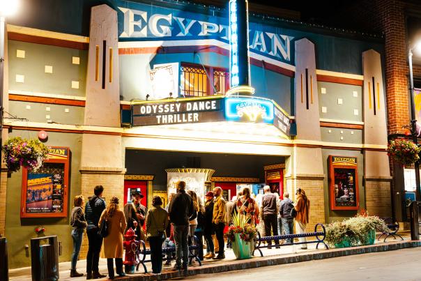A group of people listen to a guide speak about haunted buildings in front of the Egyptian Theater in Park City, UT