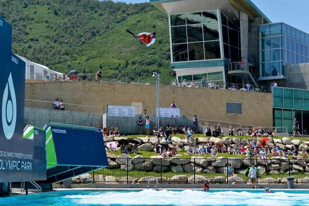 Skiers and snowboarders jump into a pool during a summer Flying Aces aerials show in front of a large crowd at the Utah Olympic Park in Park City, UT