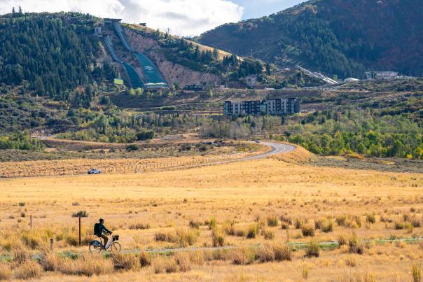 A cyclist pedals an electric bike in front of the Utah Olympic Park in Park City, UT