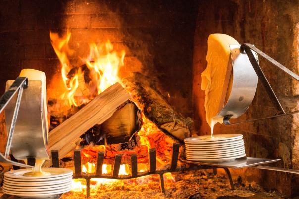 Raclette cheese melting in front of a fire at Fireside Dining in Park City, UT