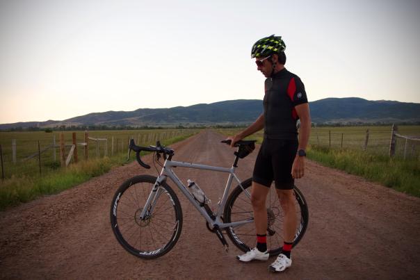 Thomas standing on dirt road with gravel bike