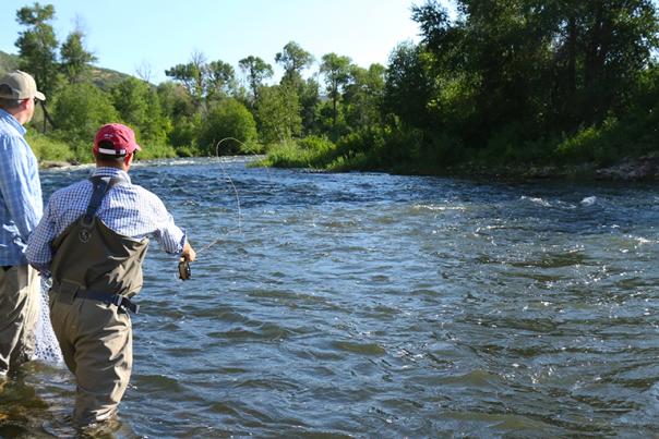 Two men fly fishing on river