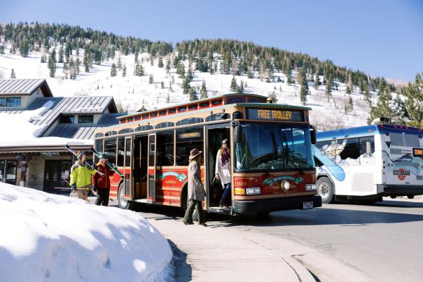 Skiers walking by people walking onto a Trolly