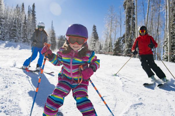 Young girl skiing with her parents
