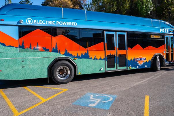 An electric bus stops in front of a handicap parking spot in Park City, UT
