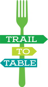 Trail-to-Table logo featuring a fork-shaped signpost with directional arrows labeled 'Trail,' 'To' and 'Table' in green, lime, and teal.