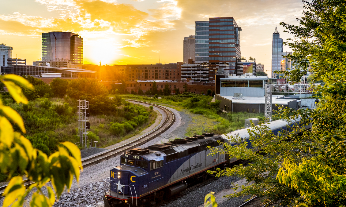 Skyline of Downtown Raleigh from the train bridge near Wye Hill with an NC Train in view