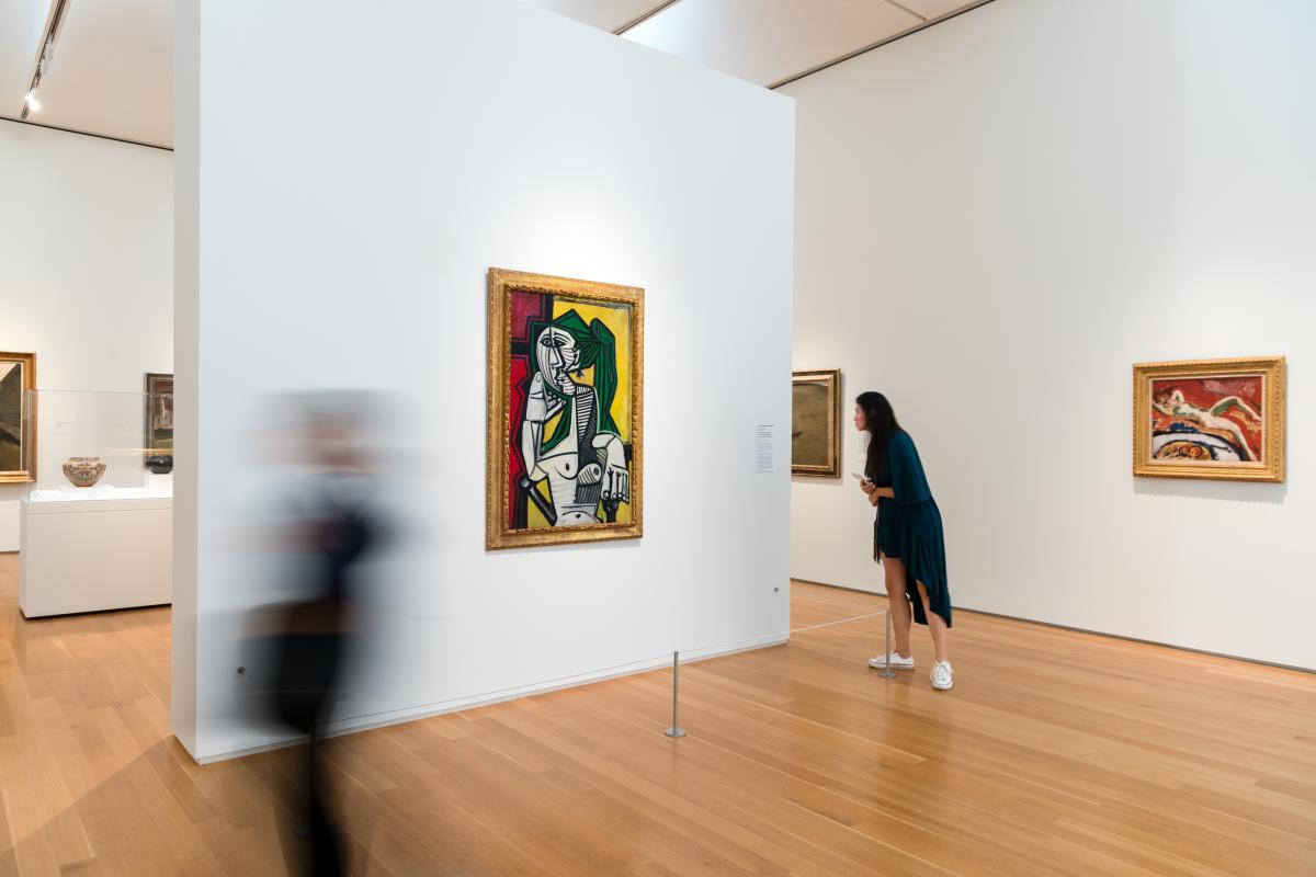 Gallery at North Carolina Museum of Art; a work by Pablo Picasso hangs on the wall as two visitors walk nearby