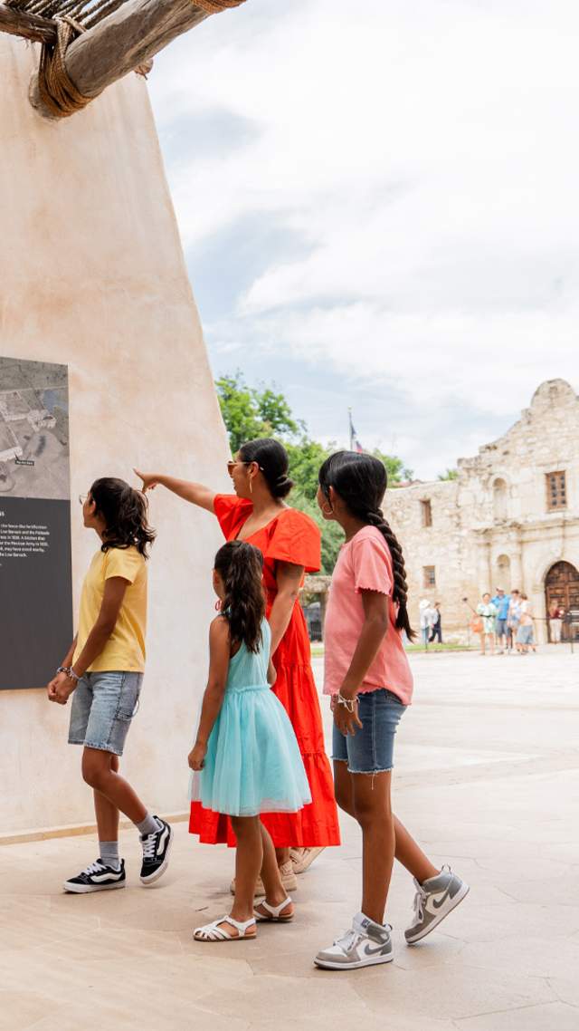 Family walking through exhibit outside of the Alamo in San Antonio, Texas.