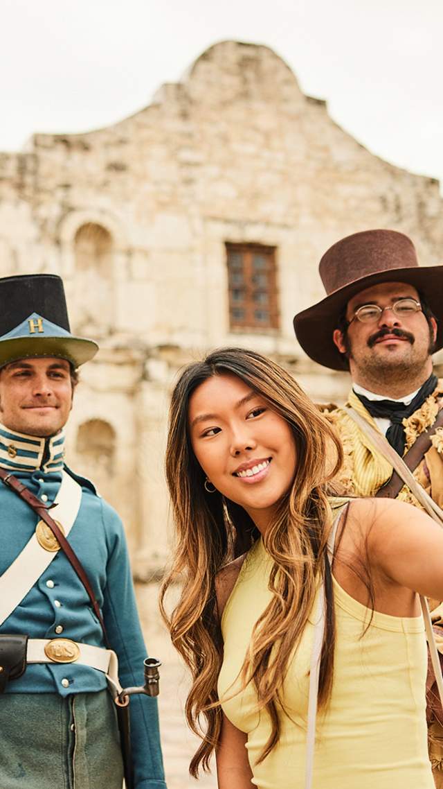 Girl taking a selfie with Alamo staff in costume