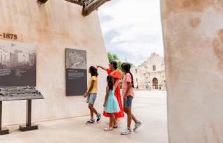 Family walking through exhibit outside of the Alamo in San Antonio, Texas.