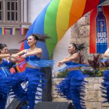 Dancers in blue uniform at Pride River Parade