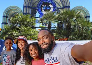 Family taking selfie in front of SeaWorld San Antonio arches
