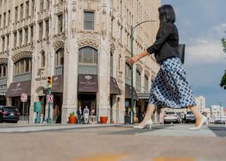 Woman in professional clothing walking in front of the Emily Morgan Hotel.