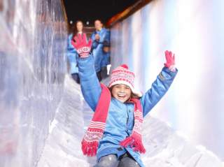 Girl sliding down ice slide at ICE! event at JW Marriott Hill Country Resort & Spa San Antonio.