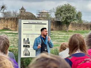 Tour guide speaking in front of San Antonio Missions