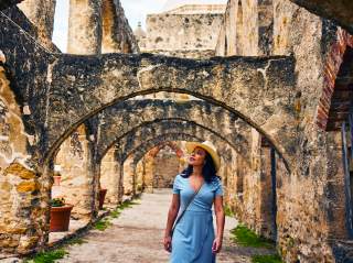 Woman walking under arches at missions