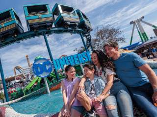 Family hugging in front of ride.