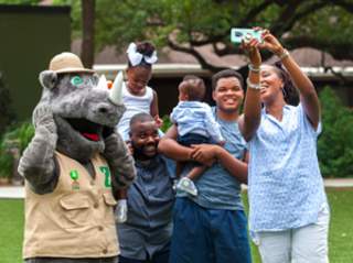 Family taking photo with costumed Rhino at San Antonio Zoo