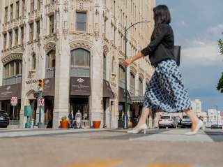 Woman in professional clothing walking in front of the Emily Morgan Hotel.