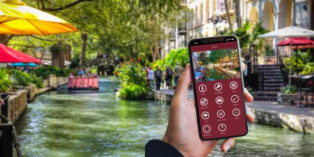 Hand holding a phone with the Visit San Antonio App