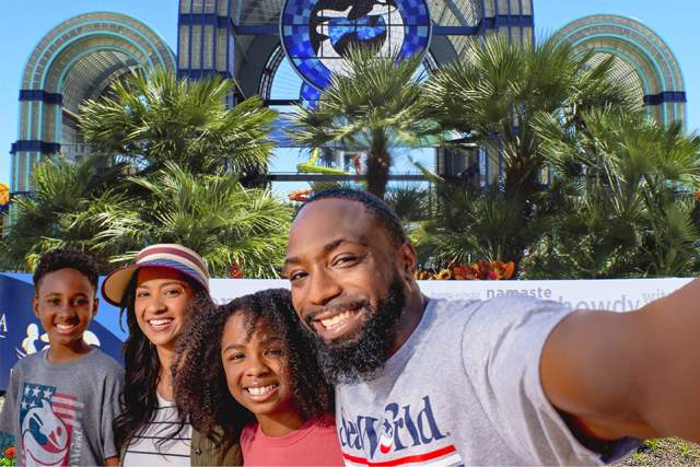 Family taking selfie in front of SeaWorld San Antonio arches