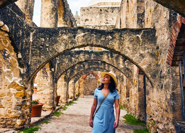 Woman walking under arches at missions