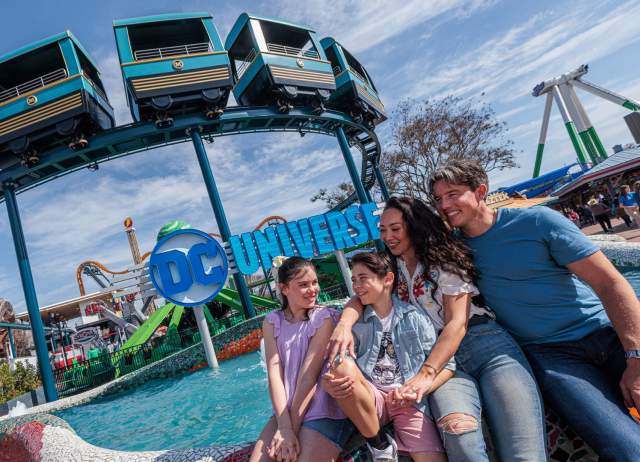 Family hugging in front of ride.