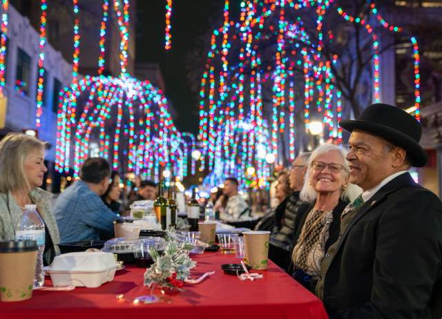 Taste of the Holidays table set up with people gathering at Houston Street in San Antonio.