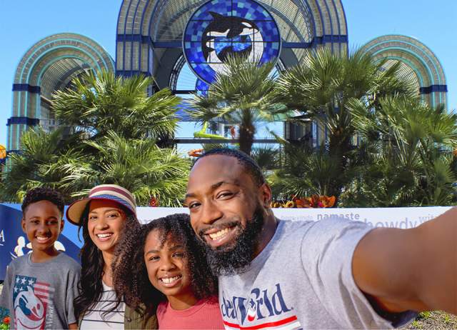 Family taking selfie in front of SeaWorld San Antonio arches
