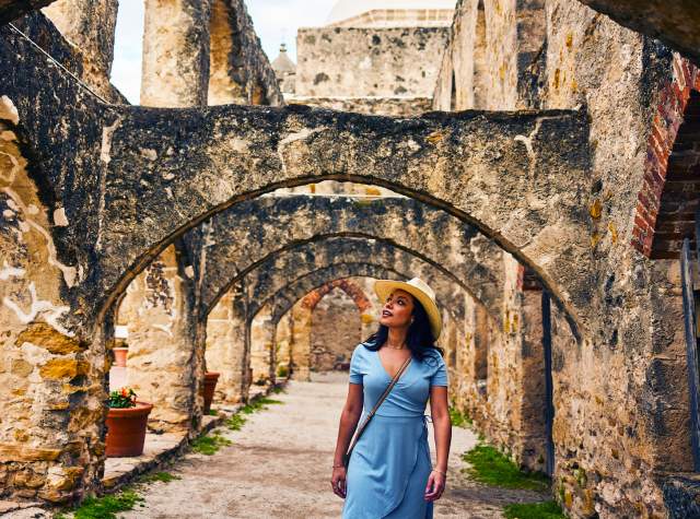Woman walking under arches at missions