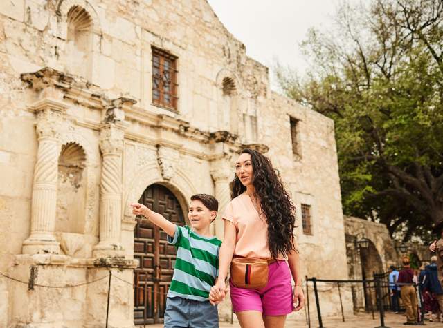 Mother and son holding hands in front of the Alamo