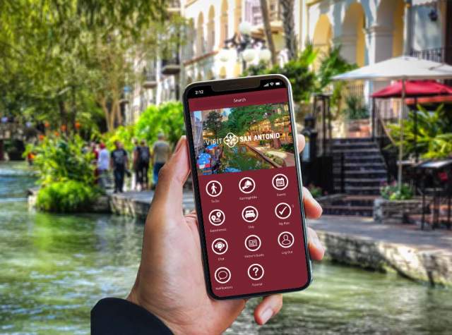 Hand holding a phone with the Visit San Antonio App