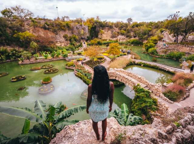 Woman overlooking lush garden and standing water