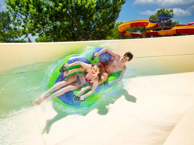 Two riders on a two-rider tube on a waterslide