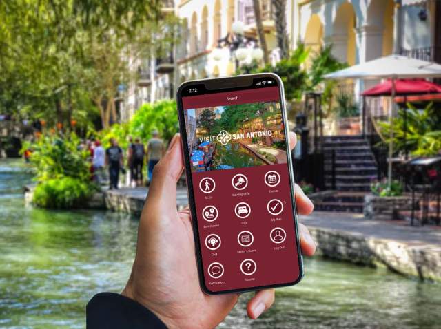 Hand holding a phone with the Visit San Antonio App