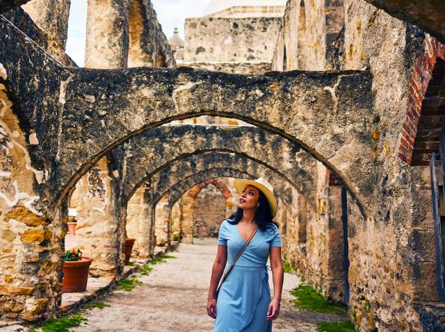 Woman walking under arches at missions